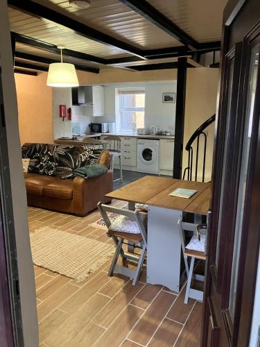 a kitchen and living room with a table and a couch at Knockers Retreat, St Agnes in St. Agnes
