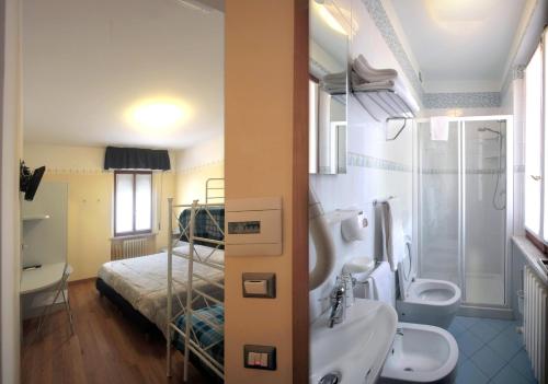 a bathroom with a bed and a sink and a toilet at Hotel Centrale in San Benedetto del Tronto