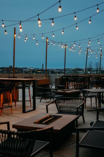 a patio with tables and chairs and lights at Le Meridien Arlington in Arlington