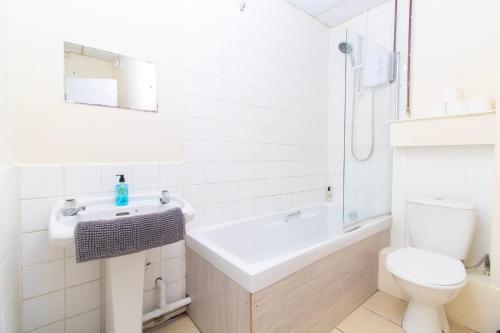 a bathroom with a sink and a toilet and a tub at Brookvale Road Guest House Room 7 in Southampton