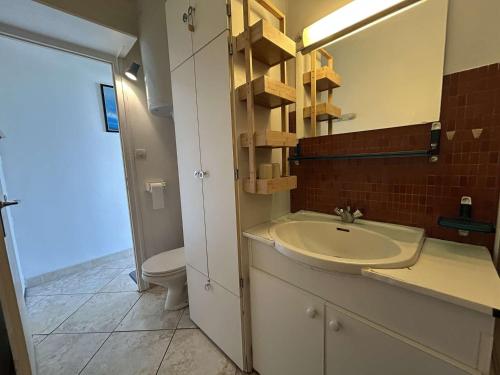 une salle de bain avec un lavabo, des toilettes et un miroir dans l'établissement Studio bord de mer avec parking - Saint-Jean-de-Monts - FR-1-224C-347, à Saint-Jean-de-Monts