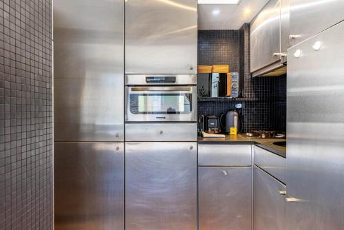 une cuisine avec un réfrigérateur et des comptoirs en acier inoxydable dans l'établissement GuestReady - Charming stay near Sainte-Chapelle, à Paris