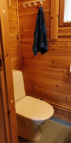 a bathroom with a toilet and a towel on a wall at Cottage on Lake Jeris in Muonio