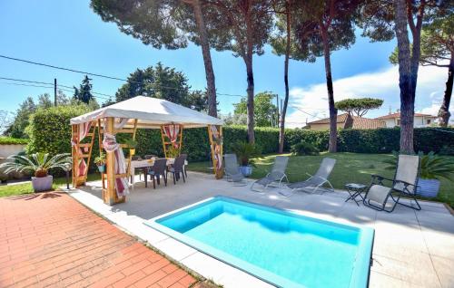 a swimming pool with a tent and a table and chairs at Villetta Della Pace in Lido di Camaiore
