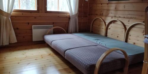 a bedroom with a bed in a wooden room at Cottage on Lake Jeris in Muonio