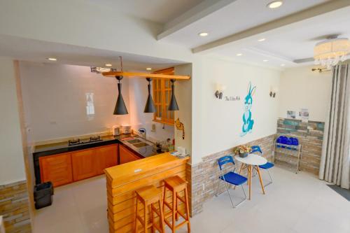 a kitchen with a counter and a table and chairs at Home Thỏ Vân Anh in Da Lat