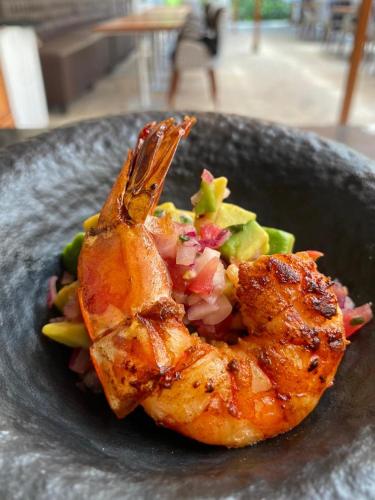 a plate of food with shrimp and vegetables on it at Lake Elementaita Manor in Gilgil