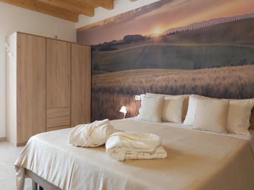 a bedroom with a bed with a painting on the wall at Cascina Olmetto di Sotto in Ghedi