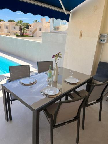 a dining table and chairs with a view of a pool at La casa de Lucas in Orihuela