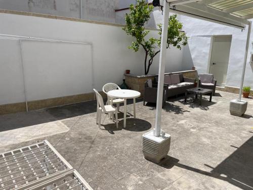 Un patio con una mesa y sillas y un sofá. en Dimora Vincenzo, en Gallipoli