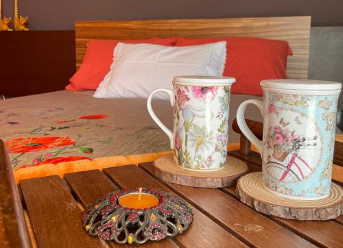two vases sitting on a wooden table next to a bed at Luxurious Seaside Suite - Garden - Ping Pong Table - near Porto in Lavra
