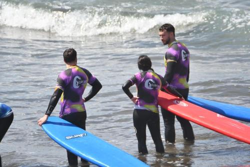 a group of people standing in the ocean with surfboards at 70's Hostel in Ericeira