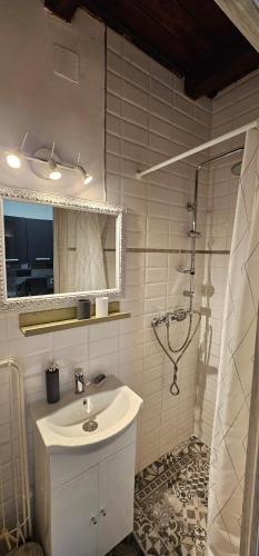 a white bathroom with a sink and a shower at Balatomi Apartman in Balatonföldvár
