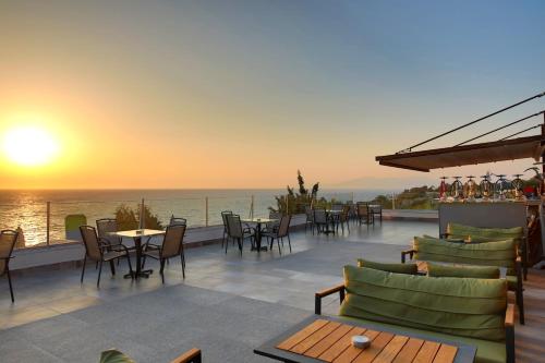 a restaurant with a view of the ocean at sunset at Sealight Resort Hotel in Kusadası