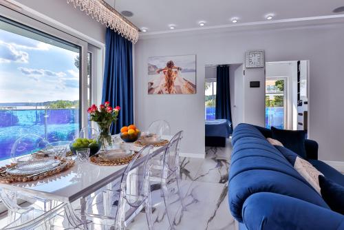 a living room with a blue couch and a table at Apartamenty Boszkowo Aquarius Platinum in Boszkowo