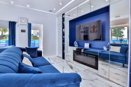a living room with a blue couch and a fireplace at Apartamenty Boszkowo Aquarius Platinum in Boszkowo