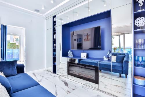 a blue living room with a blue couch and a fireplace at Apartamenty Boszkowo Aquarius Platinum in Boszkowo