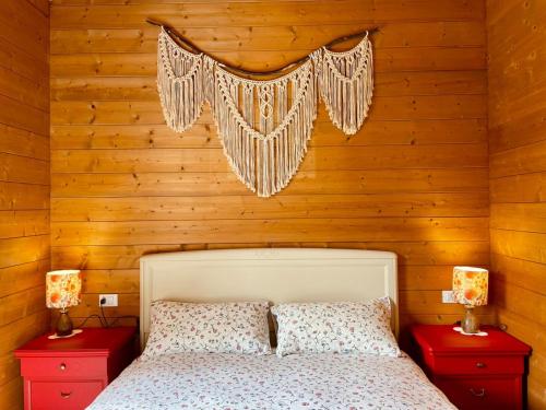 a bedroom with wooden walls and a bed with two red night stands at Casa Viva B&B in Trivero