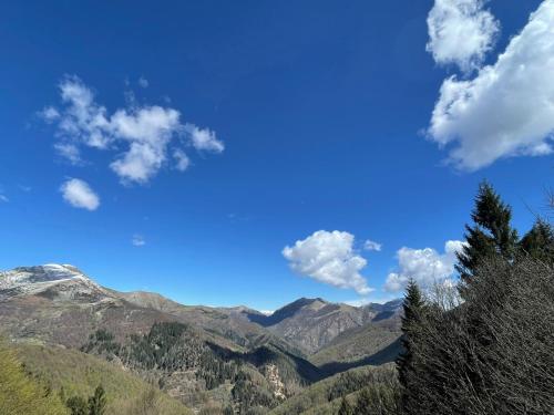 a blue sky with clouds over mountains and forests at Casa Viva B&B in Trivero