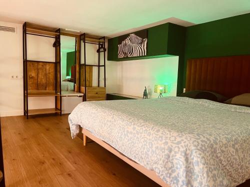 a bedroom with a bed and a green wall at Dúplex tipo loft de estilo selvático y safari, con encanto y a pasos del mar in Valencia