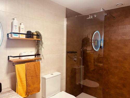 a bathroom with a shower and a white toilet at Dúplex tipo loft de estilo selvático y safari, con encanto y a pasos del mar in Valencia