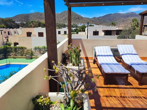 einen Balkon mit 2 Liegestühlen und einem Pool in der Unterkunft Casa Eck San Jose in San José