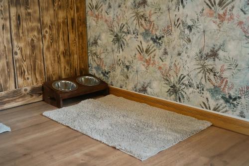 a room with a rug and a dog bowl on a wall at Idyllische Ferienwohnung im Kalletal in Kalletal