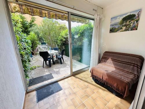 Cette chambre dispose d'un lit et d'une terrasse avec une table. dans l'établissement Studio confortable près de la plage avec parking privatif - FR-1-249-422, au Cap d'Agde