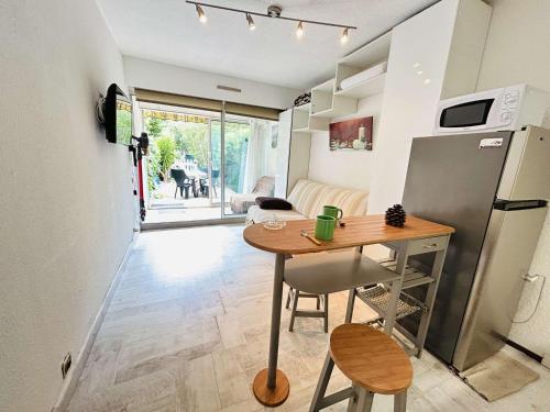 une petite cuisine avec une table et un réfrigérateur dans l'établissement Studio confortable près de la plage avec parking privatif - FR-1-249-422, au Cap d'Agde
