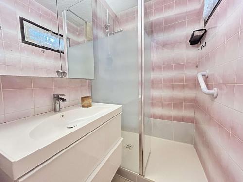 La salle de bains est pourvue d'un lavabo et d'une douche avec du carrelage rose. dans l'établissement Studio confortable près de la plage avec parking privatif - FR-1-249-422, au Cap d'Agde