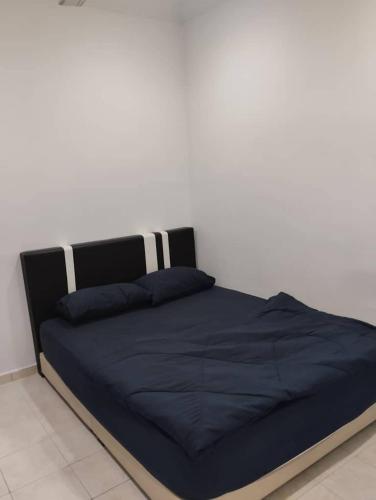 a bed with a blue comforter in a bedroom at ISLAMIC HOMESTAY CASA NAUFAL FULLY AIRCOND for 1LR 3BR in Port Dickson