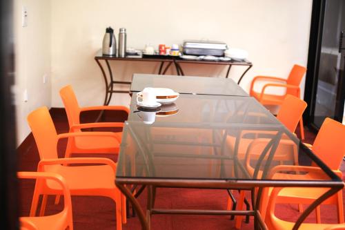 a dining room with a table and orange chairs at Gold Palm Hotel in Gulu