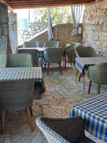 a restaurant with tables and chairs and a stone wall at Star in Mali Lošinj