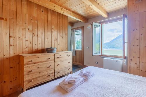 a bedroom with a bed with a dresser and a window at Beautiful Dream in Perledo