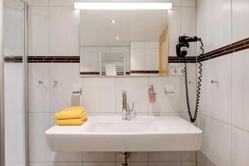 a white bathroom with a sink and a shower at Gasthaus Heiligenbrunnen in Titisee-Neustadt