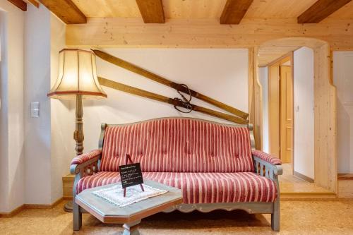 a living room with a red couch and a table at Gasthaus Heiligenbrunnen in Titisee-Neustadt
