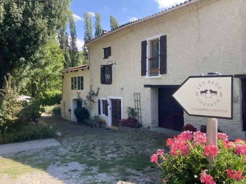 a house with a sign in front of it at Les Deux Chevaux Chambres d’Hôtes in Rouvenac