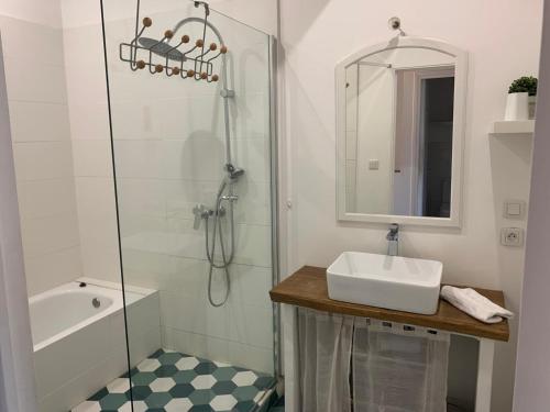 une salle de bain blanche avec un lavabo et une douche dans l'établissement La maison de Marie - Jardin arboré - Garage privatif - Netflix, à Carcassonne