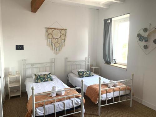 une chambre avec deux lits et une fenêtre dans l'établissement La maison de Marie - Jardin arboré - Garage privatif - Netflix, à Carcassonne