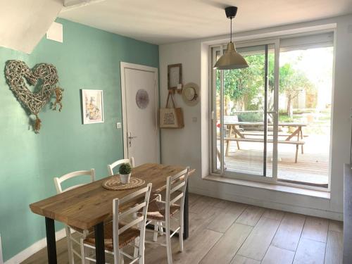 une salle à manger avec une table et des chaises en bois dans l'établissement La maison de Marie - Jardin arboré - Garage privatif - Netflix, à Carcassonne