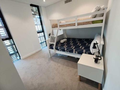 a small bedroom with bunk beds and a table at Luxury Apartment St Leonards in Sydney