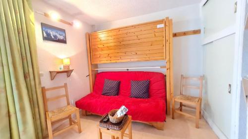 - une chambre avec un lit rouge et deux chaises dans l'établissement Plein Sud C N3102 - ST2, à Les Deux Alpes