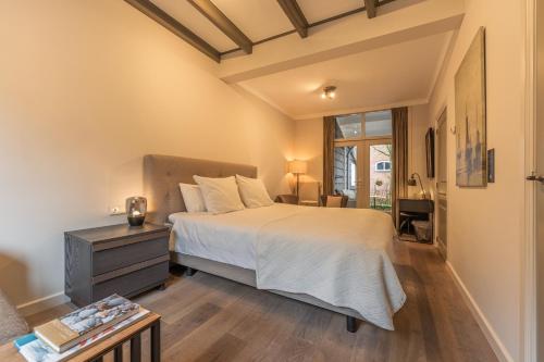 a bedroom with a large bed and a table at Villa Magnolia in Oostkapelle