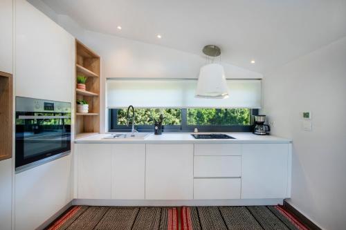 a kitchen with white cabinets and a window at The Gem Loft City Apartment in Rhodes Town
