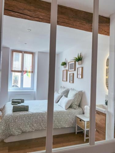 une chambre avec un lit et un grand miroir dans l'établissement Escapade Chambertine au cœur de Gevrey-Chambertin, à Gevrey-Chambertin