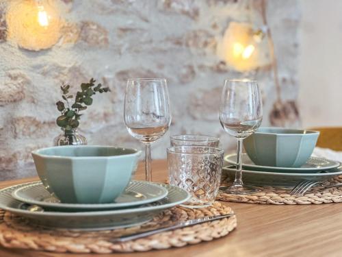 a table with two plates and two glasses of wine at Escapade Chambertine au cœur de Gevrey-Chambertin in Gevrey-Chambertin
