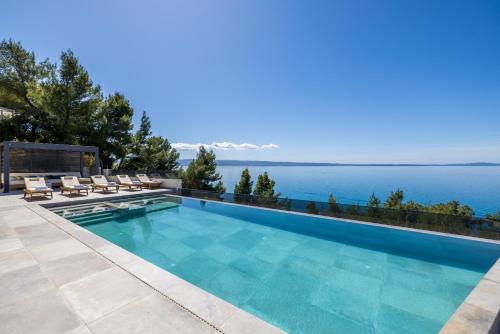 a swimming pool with a view of the water at Seaside Villa Leonis - Gym, Sauna and a pool in Podstrana