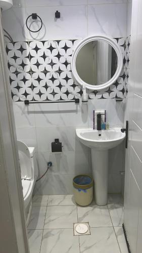 a bathroom with a sink and a mirror and a toilet at Hala 9B استوديو فندقي فاخر في قلب الملقا in Quai