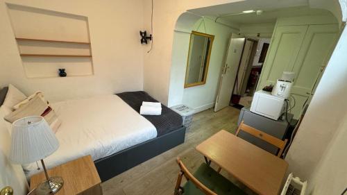 Camera piccola con letto, tavolo e scrivania. di Economic room Sheperds Bush - hotel-like room a Londra