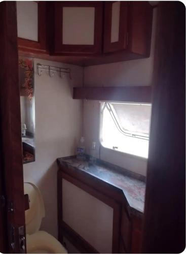 a small kitchen with a window in a small room at Trailer cipó com ar condicionado 800m do centro in Santana do Riacho